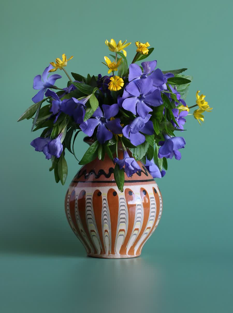 A loose, generous bouquet of wildflowers and grasses in a clear vase.